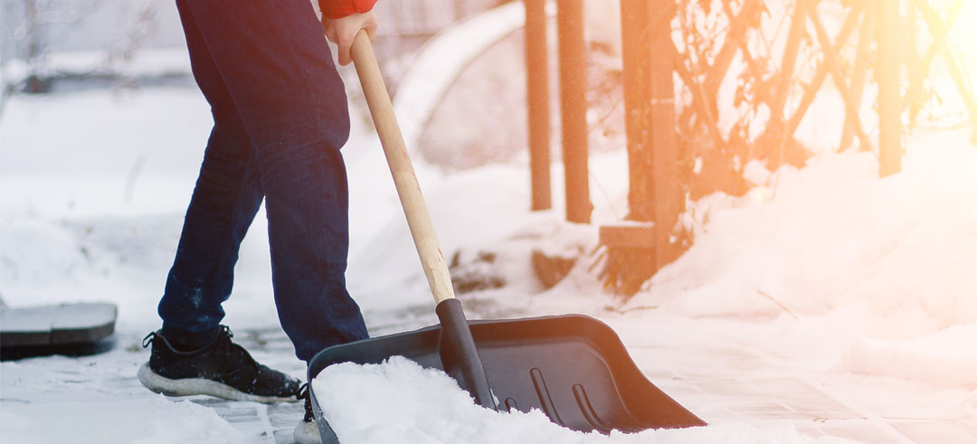 Persona recogiendo nieve con una pala