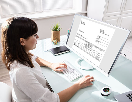Mujer consultando una factura desde el ordenador