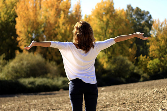 Mujer estirándose en un bosque
